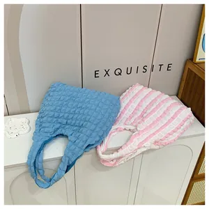 Close-up of pleated bubble fabric texture on sky blue and striped tote bags