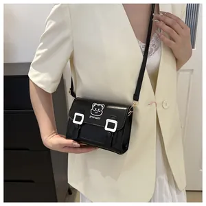 Detail shot of a black PU leather crossbody bag featuring a cute white cartoon cat print