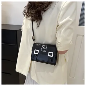Detailed view of black PU leather crossbody bag featuring cartoon cat print and silver buckles