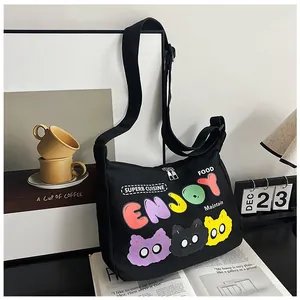 Borsa a tracolla in tela nera con stampa gatto 'ENJOY' su ambientazione ufficio