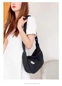 Minimalist black waffle texture crossbody crescent bag with cute cartoon pendant detail