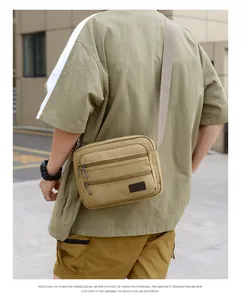 Outdoor shot showing back and side view of khaki canvas crossbody bag on a male model