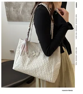Detail of white butterfly tote bag featuring pleated texture and pink polka dot silk scarf