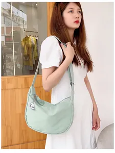 Close-up of mint green waffle texture crossbody bag with cute white dog charm detail
