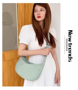 Detail view of mint green waffle textured crescent bag with adjustable wide strap