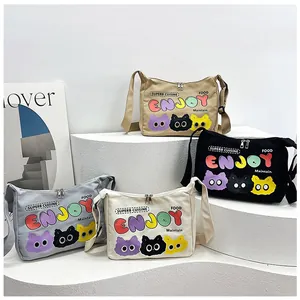 Dettaglio di quattro borse in tela colorate con stampa gatto cartoon e scritta Enjoy