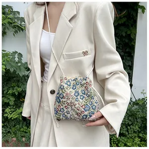 Detail of floral tapestry fabric and white cotton drawstring closure on small bucket bag