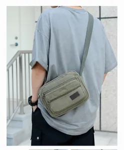 Detail view of durable military green canvas shoulder bag with multiple zip pockets