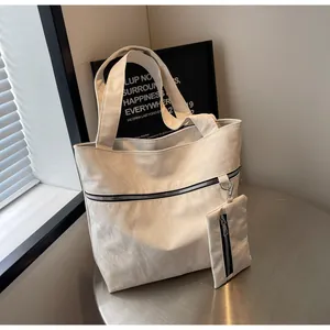 Detail of off-white tote bag with pleated texture, wide strap and small hanging pouch