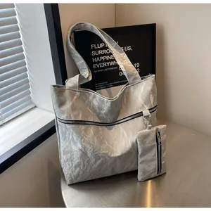 Detail of silver crinkled texture tote bag and matching pouch with metallic finish