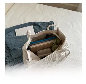 Spacious interior of white pleated tote bag showing umbrella, tablet and daily essentials
