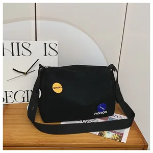 Detalle del bolso de hombro negro con parche amarillo de China y emblema azul de fashion