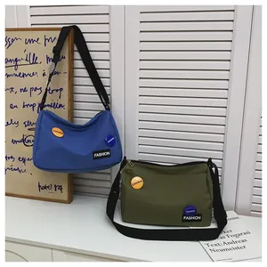 Detalle de los bolsos bandolera de lona azul y verde oliva de gran capacidad con correa ajustable