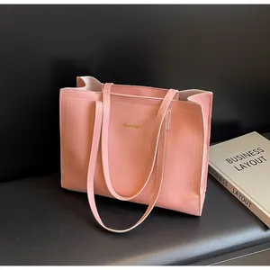 Vue détaillée du cabas en cuir rose avec logo doré embossé et doubles anses élégantes