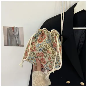 Detail of floral jacquard canvas bucket bag with tassel drawstring closure