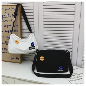 Vista de detalle de bolsos de lona grandes con parches modernos y correa ajustable