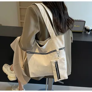 Detail of off-white oversized tote bag with pleated texture and matching mini pouch