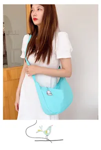Detail of light blue waffle texture crescent bag with cute dog pendant accessory