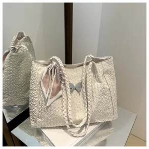 Detail of off-white pleated tote bag with silver butterfly hardware and pink silk scarf