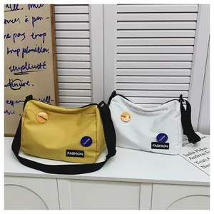 Detalle de bolsos de lona amarillos y blancos con correa ancha ajustable para hombro