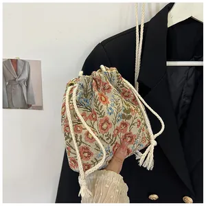 Detailed shot of vintage floral jacquard fabric bag with drawstring and tassel details