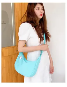 Detail of light blue crescent crossbody bag featuring a cute white puppy charm
