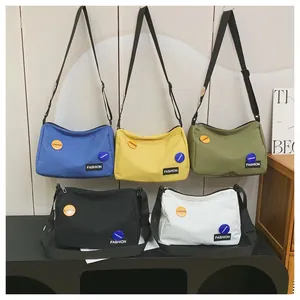 Vista detallada de bolsos de hombro grandes de lona en cinco colores con correas ajustables