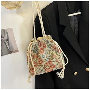 Detail of floral jacquard canvas bucket bag with cotton drawstring and woven strap