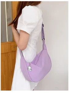 Detailed side view of a purple waffle fabric crescent bag with a cute dog pendant accessory