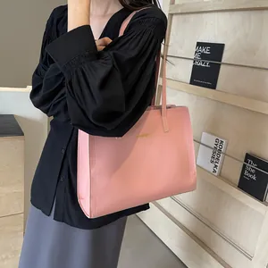 Sac fourre-tout en cuir rose avec logo doré et fines anses pour porter à l'épaule