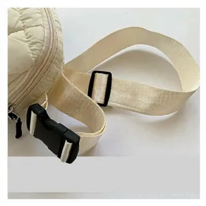 Détail de la bandoulière réglable en nylon avec boucle sur le sac à bandoulière crème