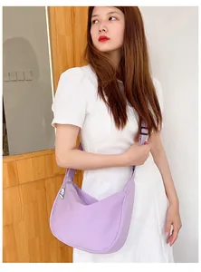 Detail of light purple waffle textured crescent bag with cute cat charm on model