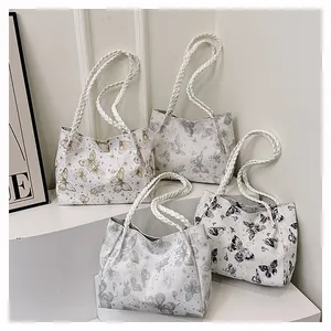 Detailed display of butterfly print leather tote bags with woven handles in four colors