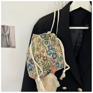 Detailed macro view of the small floral canvas bucket bag with drawstring and tassels