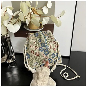 Detail of floral jacquard canvas bucket bag with cotton drawstring and tassels