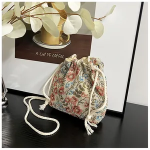 Detail of floral tapestry bucket bag showing woven texture and white cotton drawstring