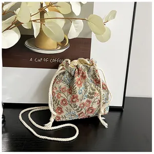 Close-up of floral drawstring bucket bag with thick cotton rope and woven texture