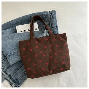 Close-up of brown corduroy tote bag with strawberry embroidery and vintage style