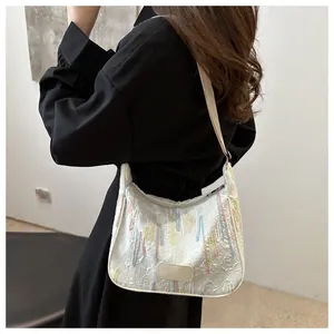 Detail of white nylon shoulder bag with colorful bead embroidery and letter pattern
