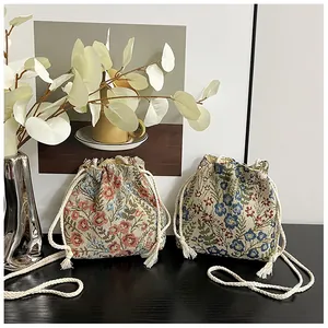 Close-up of small floral canvas bucket bags with woven texture and drawstring detail