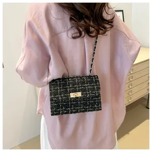 Detail of tweed crossbody bag with gold-tone hardware and leather chain strap worn by model