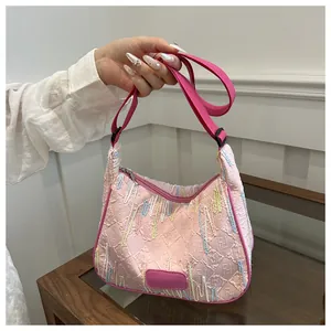 Detail of pink quilted hobo bag featuring FF logo embossing and colorful embroidery stripes