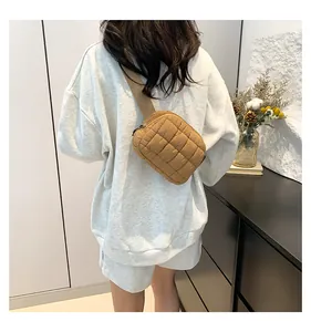 Foto lifestyle di una borsa a tracolla trapuntata kaki indossata sopra una felpa grigia