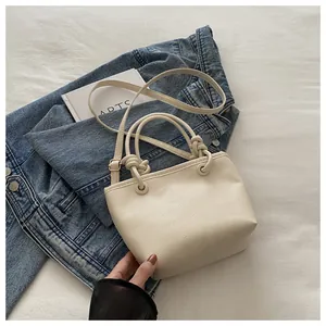 Detailed view of cream lychee texture leather handbag with unique thick rope knot handle