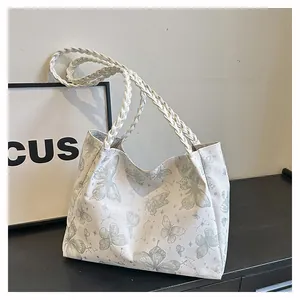 Detail of white tote bag with green butterfly prints and thick woven rope handles