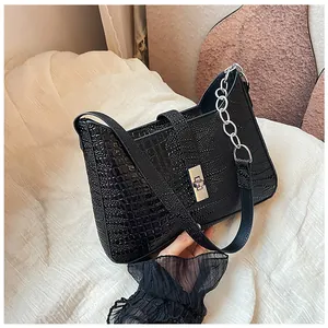 Close-up of black crocodile pattern leather underarm bag with silver twist lock and chain