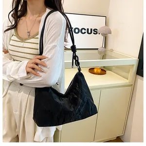 Detail of black pleated hobo bag with unique knotted strap for stylish daily commuting