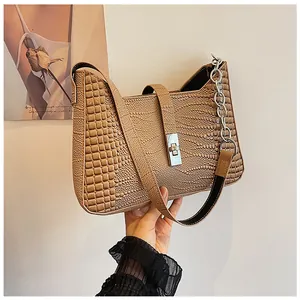 Detail of crocodile embossed leather shoulder bag with silver rectangular twist lock