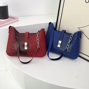 Detail of trendy faux crocodile texture shoulder bags with silver chain strap and metal lock