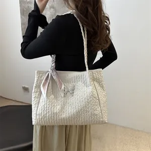 Off-white pleated tote bag with silver butterfly buckle and floral scarf on a model